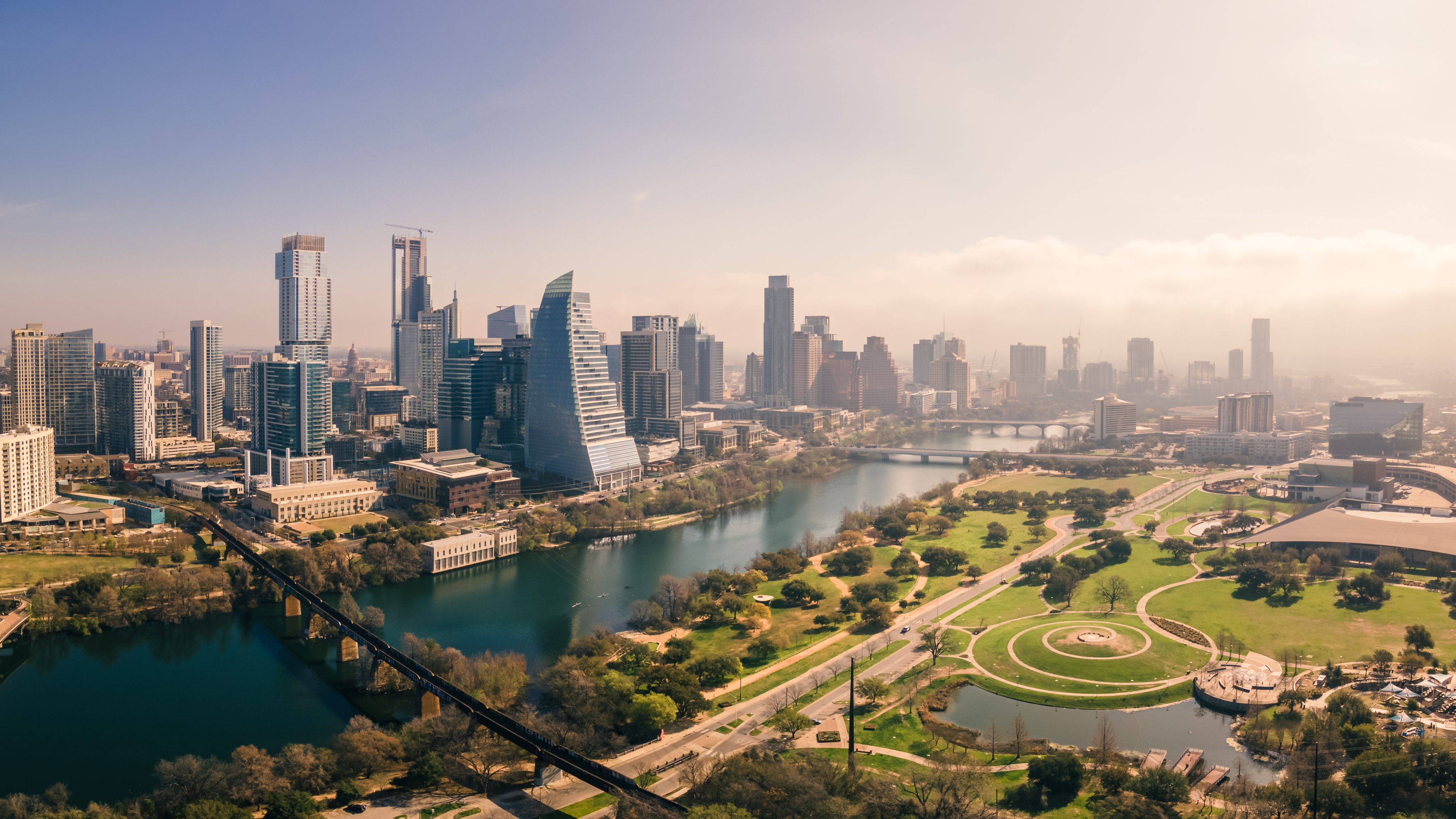 Aerial shot of city skyline with a river running through the middle and a park in the forefront